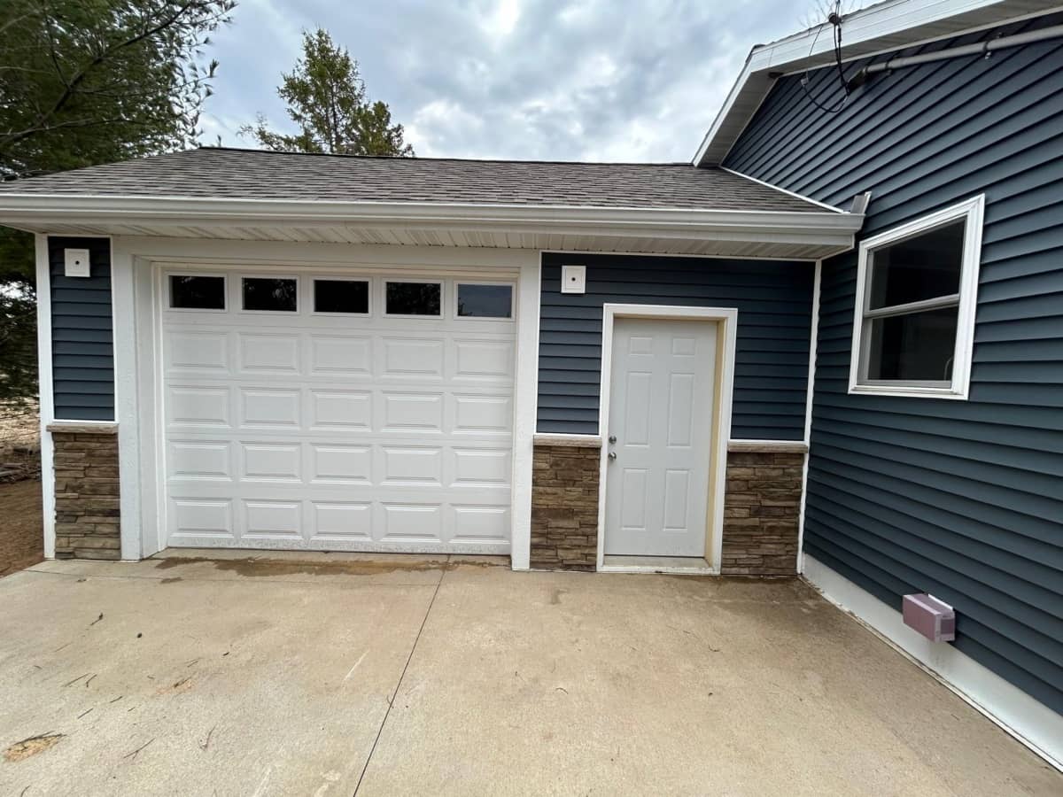 blue garage siding with bottom half masonry